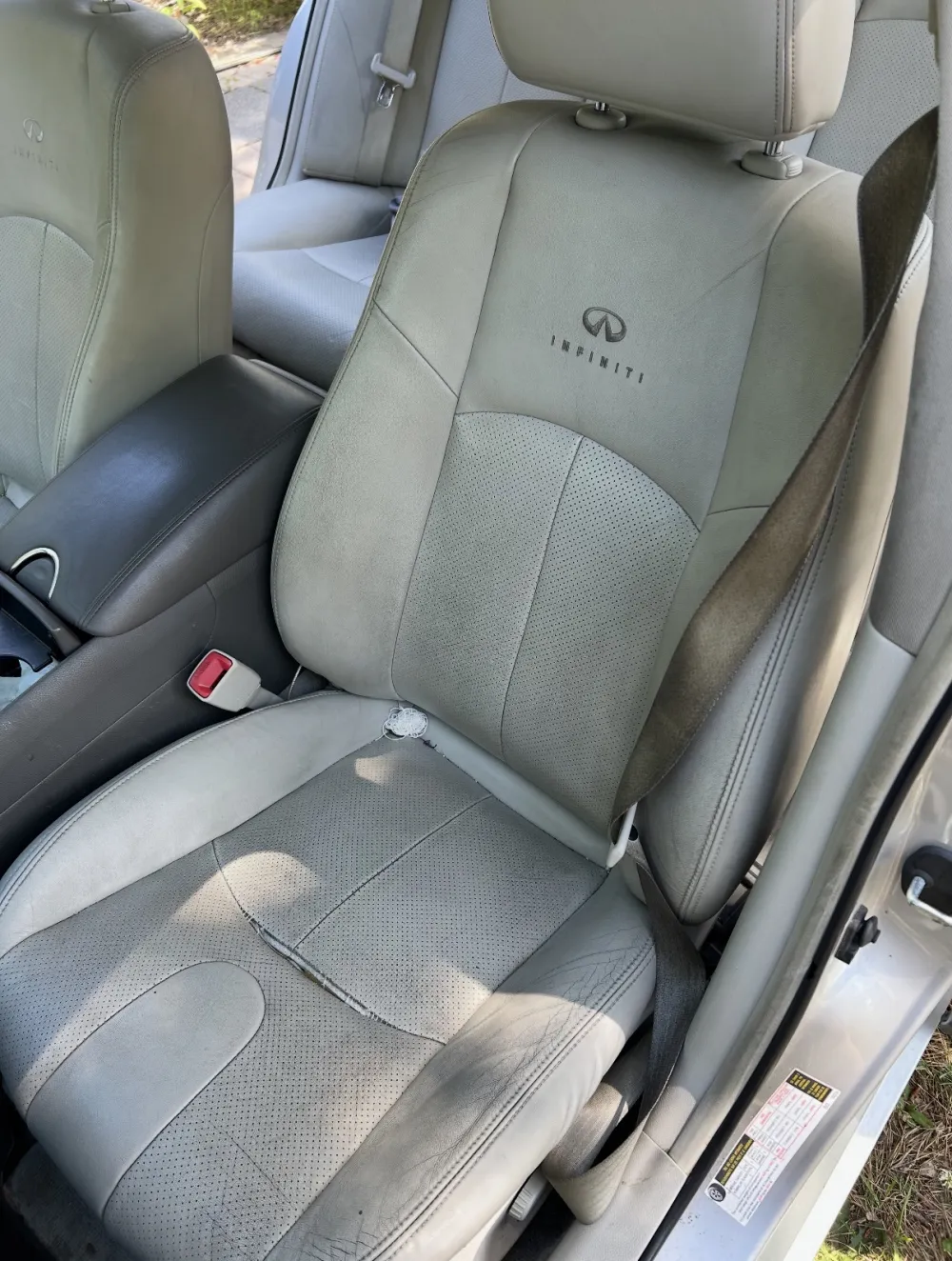 Grimy, stained Infiniti leather front seat before detailing